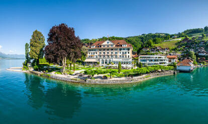 Parkhotel Gunten bei Sonnenschein mit Spiegelung im Thunersee