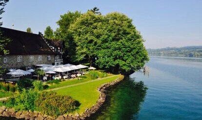 See & Park Hotel Feldbach mit Terrasse, Wiese und Bäumen am Bodensee