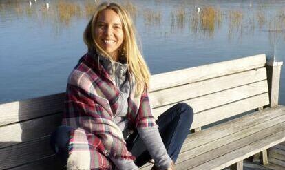 Yogalehrerin Stephanie in einer Yogastellung auf einer Bank am See