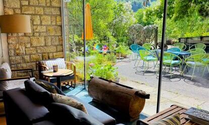 Frau im Yogasitz auf einem Wiesenhügel mit Berglandschaft