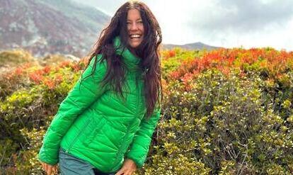 Yogalehrerin Claudia Eva Reinig in grüner Jacke im Herbst vor leuchtenden Berge 