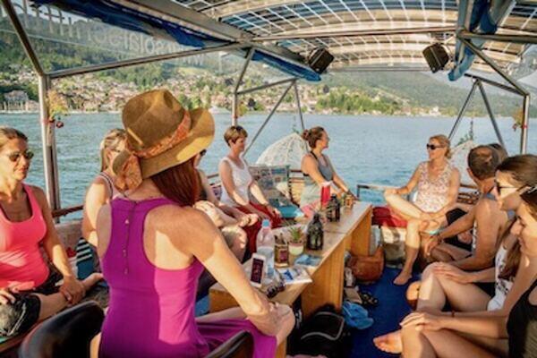 Gruppe von menschen im Sommer, die im Solarboot auf dem Thunersee sitzen, Claudia Eva Reinig mit rosa Sommerkleid und Sonnenhut