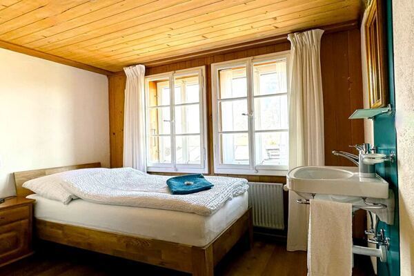 Einzelzimmer im Retreathaus Bergengel mit weissem Bett und türkissfarbenen Handtüchern