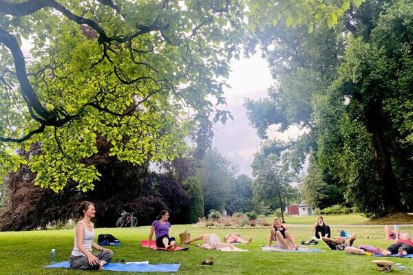 Yogaübende im Freien in Thun, im Yogasitz unter einem Baum