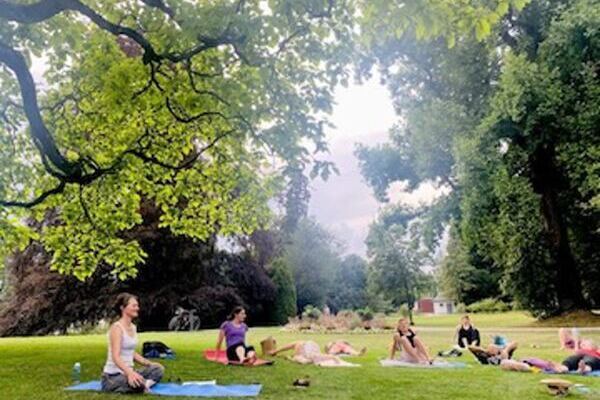 Yogaübende im Freien in Thun, im Yogasitz unter einem Baum