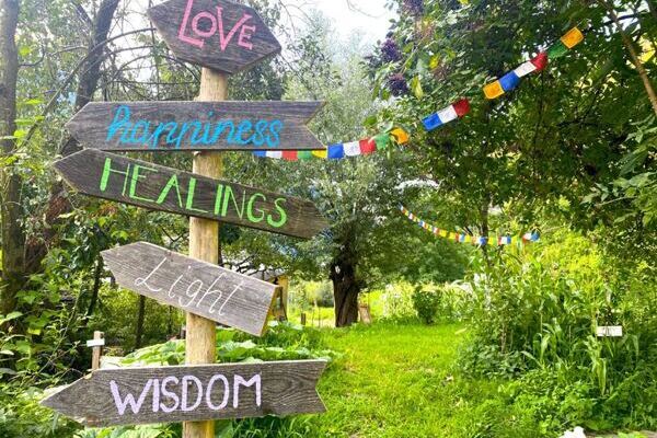 Holzwegweiser mit den Aufschriften Love, Healing, Wisdom