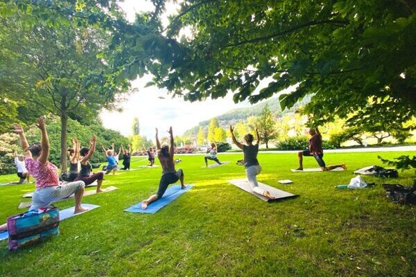 Yogaübende im Freien in Thun, in der Yogastellung Halbmond