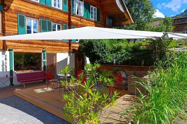 Terrasse vor altem Bauernseminarhaus mit Sonnensegel