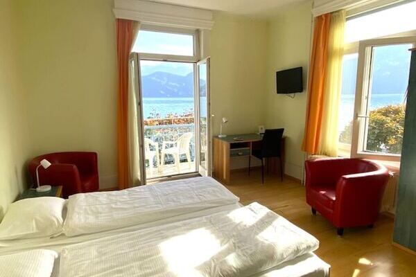 Hotelzimmer mit zwei Fenster, Blick auf den See, rote Sessel