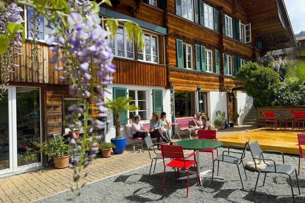 Seminarhaus Bergengel in der Schweiz mit violetter Kletterpflanze und Terrasse