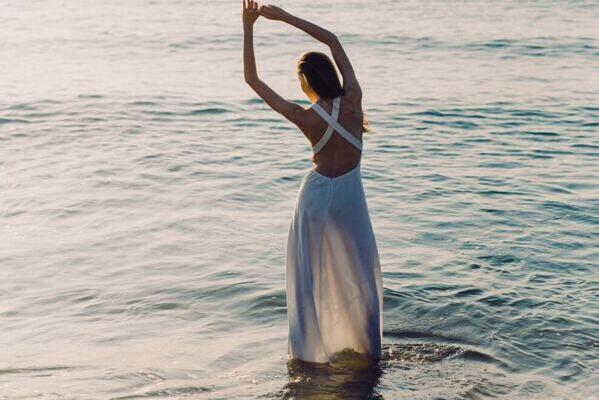Yogalehrerin Claudia Eva Reinig in Yogaposition vor dem Meer