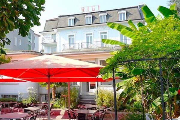 Roter Sonnenschirm im mediterranem Garten vom Hotel Rigi in Weggis