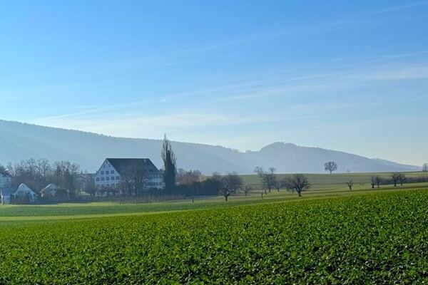 Weitblick über Felder, im Hintergrund Hotel in Mariastein beim Yoga Retreat