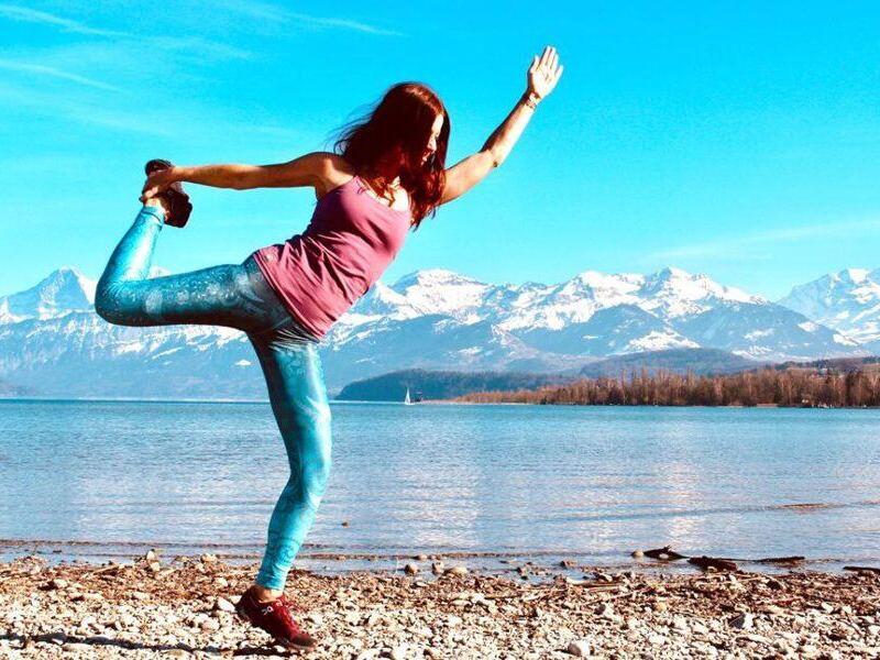 Claudia Eva Reinig in der Yogastellung Tänzer , Thunersee und Alpen im Hintergrund