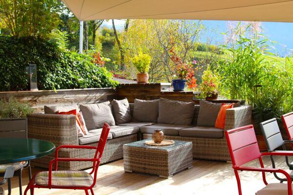 Sofaecke im Freien mit Kissen und Dekopflanzen 